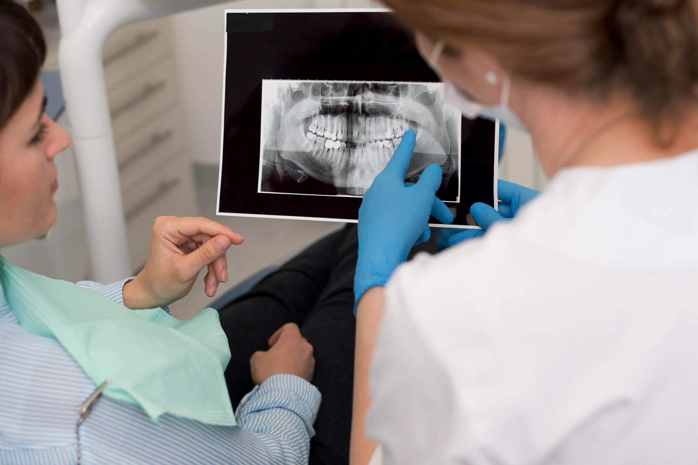 female-patient-looking-radiography-her-teeth-with-dentist